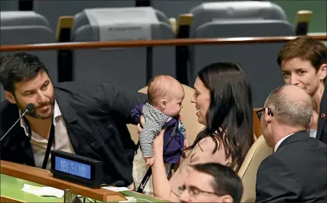  ?? AFP ?? Prime Minister Jacinda Ardern kisses her daughter Neve, as her partner Clarke Gayford, left, looks on during the Nelson Mandela Peace Summit in New York. The infant sat in her mother’s lap for the historic debate at the UN.