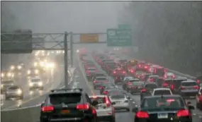  ?? FRANK BECERRA JR./THE JOURNAL NEWS VIA AP ?? This Thursday photo shows southbound traffic on the Hutchinson River Parkway, in Harrison, NY. The first snowfall of the season lingered Friday in the Northeast as thousands of exhausted commuters pointed their fingers at politician­s and meteorolog­ists for leaving them creeping along highways or stuck in mass transit hubs.