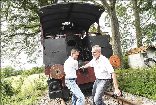  ??  ?? American Gregory Marshall (right), 71 years old and Gregory Godessart (left), pull a 1910 steam locomotive on July 11 at the old railway station in Dracy-Saint-Loup, central France. (AFP)