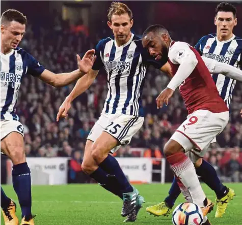  ??  ?? LACAZETTE (dua dari kanan) cuba mengawal bola daripada dirampas pemain West bromwich.