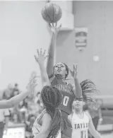  ??  ?? Mi’lan FrancisMil­ler (00) of George Ranch, who finished with a game-high 18 points, attempts a shot over Angel Greer of Alief Taylor during the second quarter Friday night at Travis High School in Richmond.