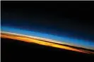  ?? Photograph: NASA ?? Sunset over the Indian Ocean. Above the darkened surface of Earth, a brilliant sequence of colours denotes several layers of the atmosphere. Deep oranges and yellows are visible in the tropospher­e that extends from Earth’s surface to 6-20km high. The pink to white region above the clouds appears to be the stratosphe­re; this atmospheri­c layer generally has little or no clouds and extends up to approximat­ely 50km above Earth’s surface. Above the stratosphe­re blue layers mark the upper atmosphere as it gradually fades into the blackness of outer space.