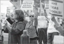  ??  ?? Susan Moffat (center) joins a protest outside the Cathedral School of Saint Mary in Austin where Sen. Dan Patrick unveiled his school reforms.