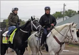  ?? GARRY JONES — THE ASSOCIATED PRESS ?? Trainer Joe Sharp, right, leads Kentucky Derby entrant Girvin, left, ridden by his wife Rosie Napravnik, a former jockey, back to Barn 33 following a morning gallop May 4 at Churchill Downs in Louisville, Ky.