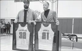  ?? Eric Sondheimer Los Angeles Times ?? FORMER DONS basketball greats Tyson Chandler, left, and Tayshaun Prince hold up their retired jerseys on Friday night in the Compton Dominguez gym.