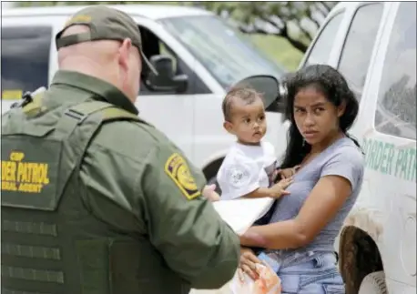  ?? DAVID J. PHILLIP — THE ASSOCIATED PRESS FILE ?? By Thomas Beaumont and Hannah Fingerhut The Associated Press In this file photo, a mother migrating from Honduras holds her 1-year-old child as surrenderi­ng to U.S. Border Patrol agents after illegally crossing the border near McAllen, Texas.
