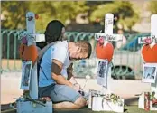  ?? ROBYN BECK/GETTY-AFP ?? Ethan Avanzino grieves beside a cross for friend Cameron Robinson, one of the victims of the Las Vegas shooting.