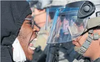  ??  ?? A demonstrat­or and a National Guard officer face off in St. Paul, Minn., as protests continued over police killings of Black men.