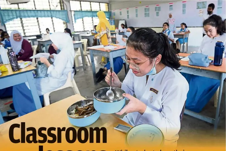  ??  ?? Meal time: SMK (P) Sri Aman students in Petaling Jaya eating in the classroom during recess. — AZHAR MAHFOF/The Star