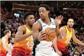  ?? AP Photo/Chris Nicoll ?? ■ San Antonio Spurs guard DeMar DeRozan (10) looks to get past Utah Jazz guard Donovan Mitchell (45) and to the basket during the fourth quarter of an NBA basketball game, Saturday in Salt Lake City. Utah won, 125-105.