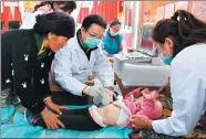  ?? LI XIN / XINHUA ?? A doctor checks a 2-year-old child who was diagnosed with echinococc­osis in Nakarze county in the Tibet autonomous region in September.