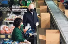  ?? Patrick Semansky / Associated Press ?? President Joe Biden packs produce while volunteeri­ng at hunger relief organizati­on Philabunda­nce in Philadelph­ia on Sunday.