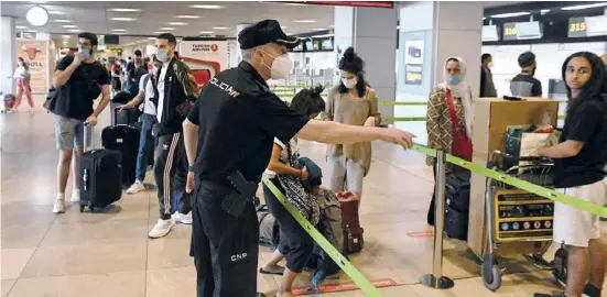  ?? Foto: efe ?? Polizisten versuchen am Flughafen, die Wartenden zu ordnen und Sicherheit­sabstände herzustell­en.