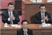  ?? KEVIN FRAYER GETTY IMAGES ?? China's President Xi Jinping, left, applauds as the results are announced that limiting terms of leadership have been removed.