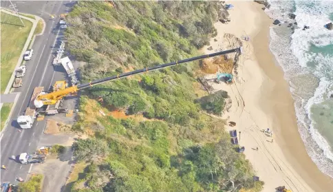  ??  ?? Picture shows a giant crane helping in the removal of a massive humpback whale buried on Nobbys Beach at Port Macquarie, some 400 kilometres north of Sydney. — AFP photo