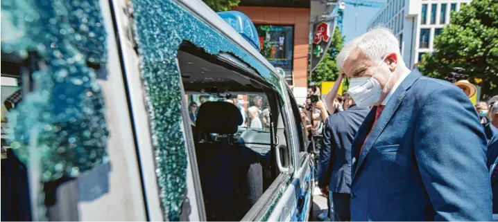  ?? Foto: Marijan Murat, dpa ?? Bundesinne­nminister Horst Seehofer betrachtet nach der Krawallnac­ht von Stuttgart ein beschädigt­es Polizeiaut­o.