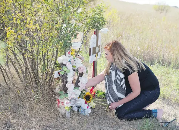  ?? TROY FLEECE ?? Dakota Schmidt visits a roadside memorial at the site of a crash where her mother was killed by an impaired driver approximat­ely 40 kilometres north of Regina on Highway 6.