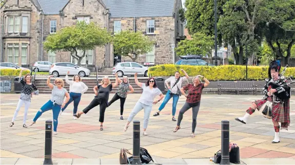  ?? Pictures: Rachel McLean. ?? Friends of bride Lisa Brennan perform a dance routine outside Kirkcaldy Town House before the wedding.