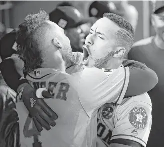  ?? Karen Warren / Houston Chronicle ?? Astros center fielder George Springer, left, and shortstop Carlos Correa celebrate Correa’s home run in the tenth inning of Game 2 Wednesday night. Springer’s two-run shot in the 11th put the Astros ahead to stay and evened the World Series at a game...