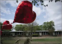  ?? ASSOCIATED PRESS ?? A heart-shaped balloon flies decorating a memorial site outside Robb Elementary School in Uvalde, Texas, Monday.