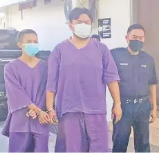  ??  ?? The suspect (middle) arrived at Tawau court compound at 8.47am yesterday.