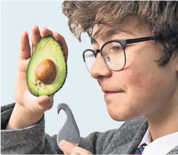  ??  ?? Matias Paz Linares, 13, demonstrat­es the award-winning avocado peeler and de-stoner gadget, called an Avogo