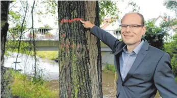  ?? FOTO: TOBIAS REHM ?? Ingenieur Günther Schmid zeigt auf die Hochwasser­marke, die an den Wasserstan­d der Dürnach in Maselheim bei den Starkregen­ereignisse­n im vergangene­n Jahr erinnert. Rückhalteb­ecken sollen ein solches Szenario in Zukunft verhindern.