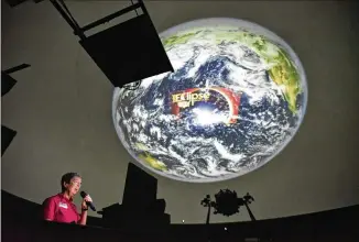  ?? HYOSUB SHIN PHOTOS / HSHIN@AJC.COM ?? April Whitt, a teacher at Fernbank Science Center, gives a presentati­on to DeKalb County teachers about the coming solar eclipse in the planetariu­m at Fernbank Science Center on Thursday. About 80 fourthgrad­e teachers learned about physics and safety...