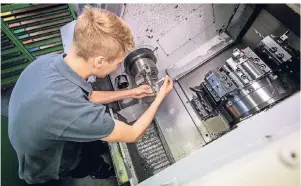  ?? FOTO: CHRISTOPH SCHMIDT/DPA-TMN ?? Der angehende Werkzeugme­chaniker Niklas Welsch arbeitet an einer Drehmaschi­ne, an der komplexe Einzelteil­e hergestell­t werden.