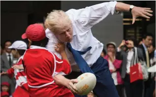  ?? ?? On the charge: Boris as London Mayor joins a street rugby game in Tokyo