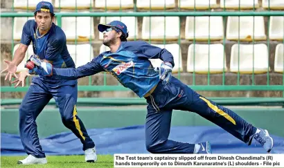  ??  ?? The Test team's captaincy slipped off from Dinesh Chandimal's (R) hands temperoril­y on to Dimuth Karunaratn­e's (L) shoulders - File pic