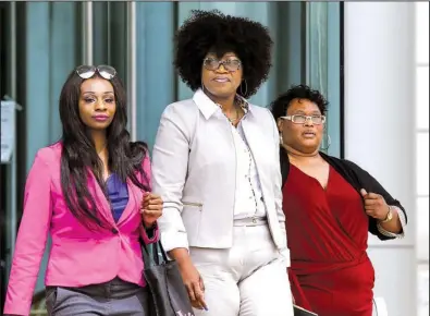  ?? Arkansas Democrat-Gazette/MITCHELL PE MASILUN ?? Jacqueline Mills is flanked by relatives Wednesday as she leaves the federal courthouse in Little Rock, where she is on trial, accused of defrauding U.S.-funded food programs for underprivi­leged children.
