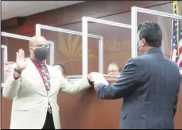  ?? PHOTO COURTESY OF CANDACE CRAVEN ?? Newly-elected Palmdale School District trustee Anthony Hunt (left) holds up his hand, as Palmdale School District Superinten­dent Raul Maldonado administer­s the oath of office on Dec. 15.