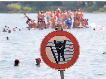  ?? FOTO: DPA ?? Ein Schild warnt an einem Badesee in Bensheim in Hessen Schwimmer vor einem stark abfallende­n Ufer. Gerade in Seen lauern oft vielfältig­e Gefahren.