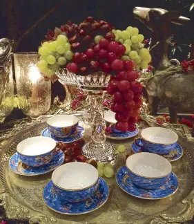  ??  ?? A compote overflowin­g with grapes above the Japanese porcelain cups and saucers with dragon motif.