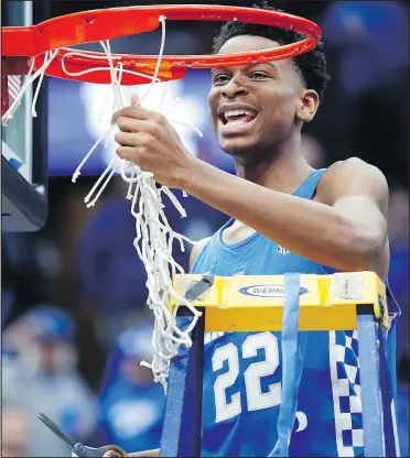  ?? THE ASSOCIATED PRESS ?? Shai Gilgeous-Alexander, of Hamilton, Ont., cuts down the net after Kentucky defeated Tennessee 77-72 to win the SEC championsh­ip. He was named tournament MVP.