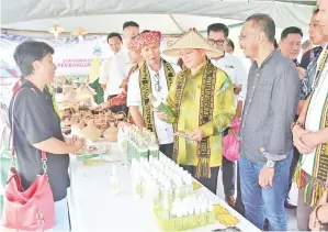  ??  ?? RASININ (tengah) melawat salah satu gerai pameran pengusaha KPLB sambil diiringi Abdul Halim.