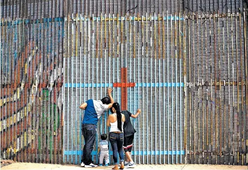  ??  ?? Breve reunión. Algunas familias se reúnen en la frontera, unos del lado mexicano y otros del estadounid­ense cerca de Tijuana. Con el muro que propone el republican­o Donald Trump esto ya no sería realidad.