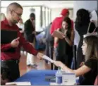  ?? LYNNE SLADKY — THE ASSOCIATED PRESS ?? An employee of Aldi, right, takes an applicatio­n from a job applicant at a JobNews USA job fair in Miami Lakes, Fla.