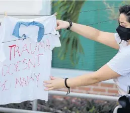  ?? STEPHEN M. DOWELL /ORLANDO SENTINEL ?? Demonstrat­ors hang clothing on a line during a protest by the Osceola Coalition for Change to bring awareness to Osceola County School District underrepor­ting sexual violence. The protest was held outside a meeting at the Osceola County School District administra­tion building in Kissimmee on Oct. 6, 2020.