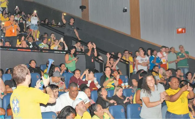  ?? Renan Schuindt ?? Com uma vuvuzela, o vendedor Luciano Santos comemora o primeiro gol brasileiro na vitória de 2 a 0 contra a Sérvia, em transmissã­o no Kinoplex do Shopping Tijuca. No Rio, 21 salas de cinema transmitem a competição