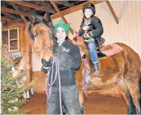  ?? DESIREE ANSTEY/JOURNAL PIONEER ?? Jasmine Bastarache holds Jack while confident rider Ella Campbell and her cat, Pepper, go for a ride around the barn at Venture Stables in Freetown.
