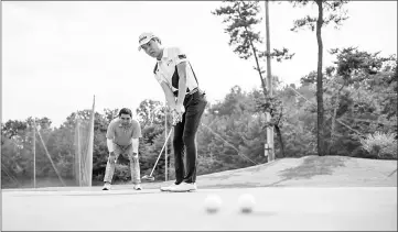  ??  ?? In a photo taken on July 14, golfer Simon Seungmin Lee (Right) practises his putting at a golf club near Anseong. — AFP photos by Ed Jones