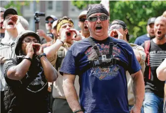  ?? Ted S. Warren / Associated Press ?? Supporters of a rally held by members of Patriot Prayer and other groups advocating for gun rights yell and cheer on Saturday at Seattle’s City Hall. At least three counterpro­testers were arrested.