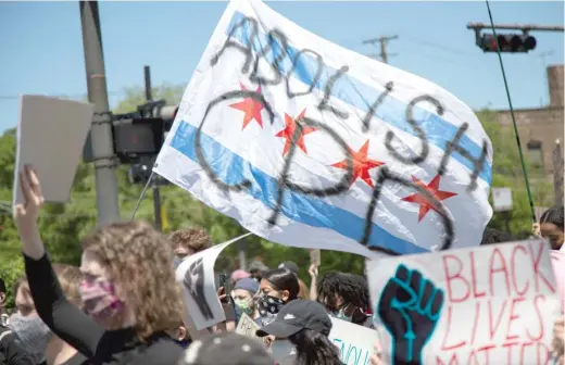  ?? ANTHONY VAZQUEZ/SUN-TIMES ?? Protesters wave an “Abolish CPD” flag on East 63rd Street in Woodlawn last June.