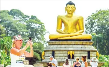  ?? AFP ?? A foreign tourist takes a photograph at the Viharamaha­devi Park in Colombo. Sri Lanka’s tourism industry is recovering faster than expected after the Easter Sunday suicide bombings shook the island nation.