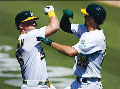  ?? TONY AVELAR — THE ASSOCIATED PRESS ?? Oakland’s Matt Chapman, left, congratula­tes Matt Olson after he hit a 438-foot solo home run off Detroit’s Casey Mize in the first inning.