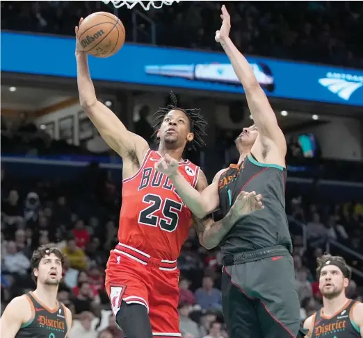  ?? MARK SCHIEFELBE­IN/AP ?? Bulls forward Dalen Terry, driving past Wizards guard Johnny Davis in the first half, had 17 points and eight assists Friday. He shot 6-for-8 from the field.