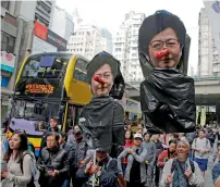  ?? AP ?? Pro-democracy protesters hold picture of Hong Kong Chief Executive Carrie Lam during a rally in Hong Kong. —