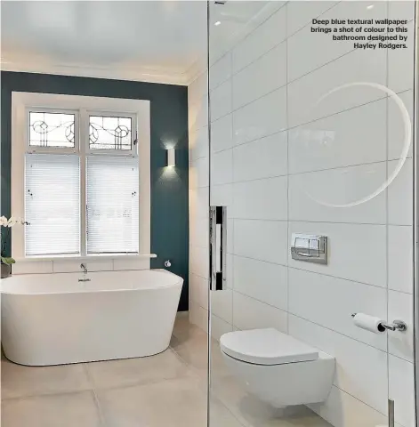  ??  ?? Deep blue textural wallpaper brings a shot of colour to this bathroom designed by Hayley Rodgers.